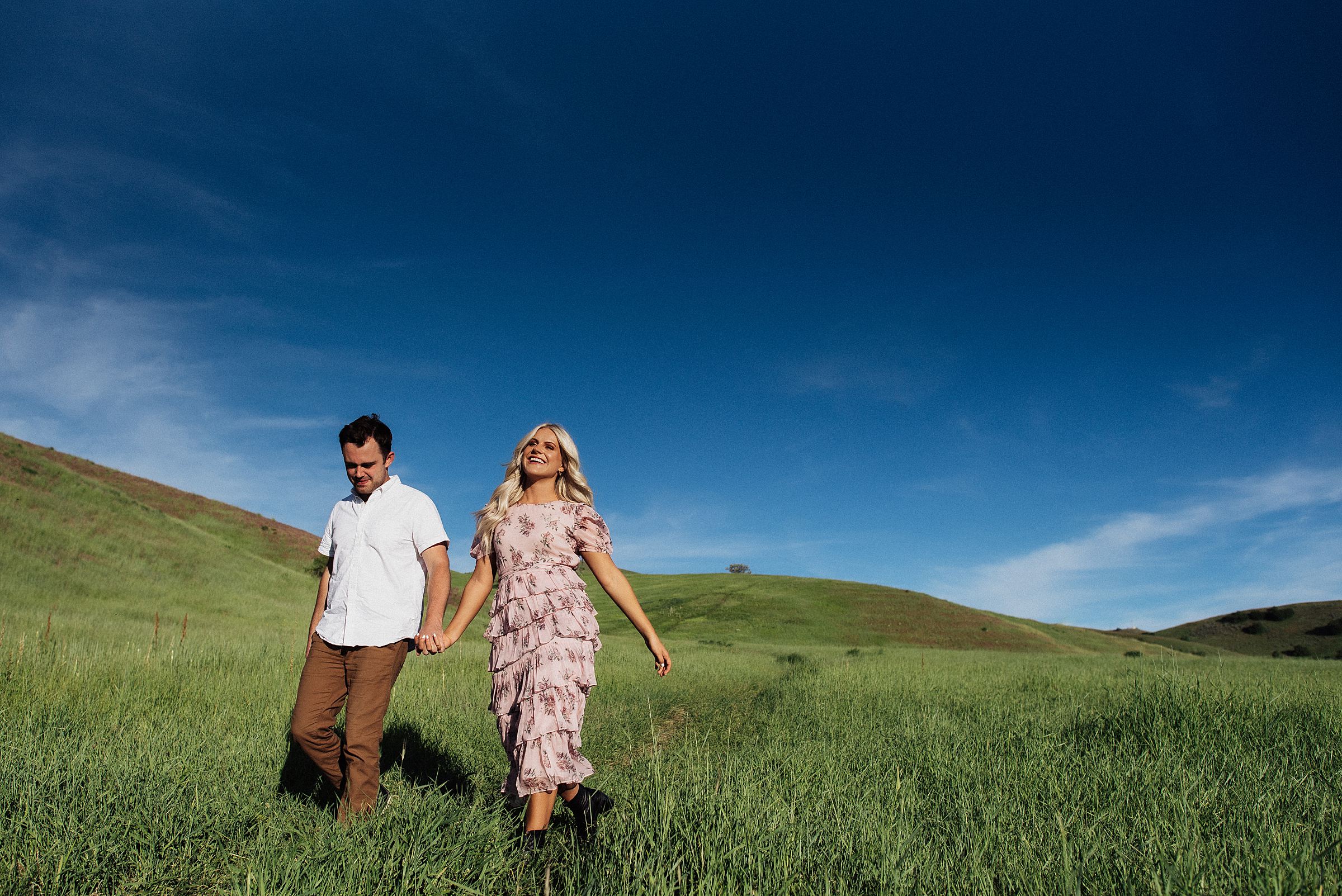 walking in field in tunnel springs engagement session