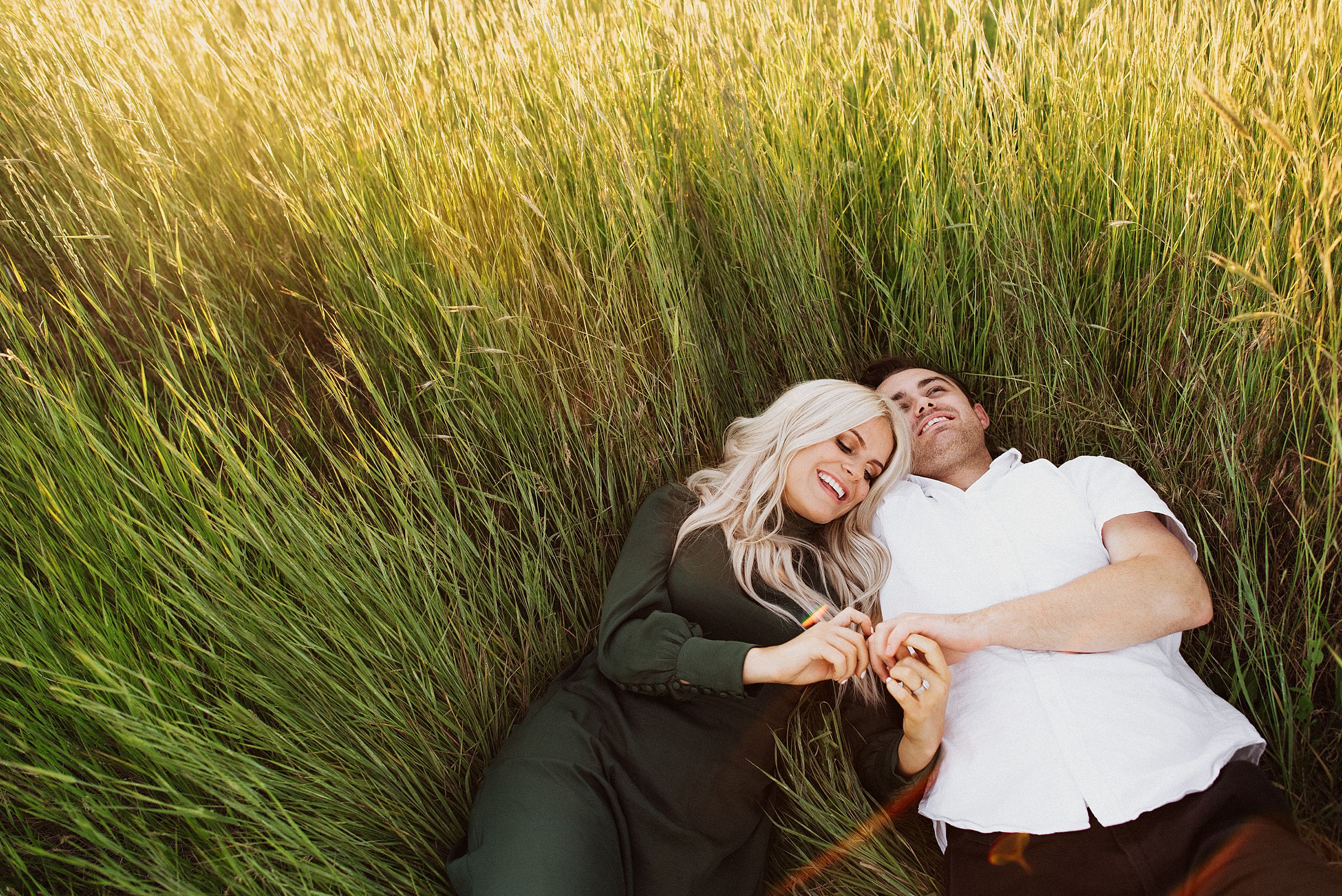 laying in field at tunnel springs for engagement session